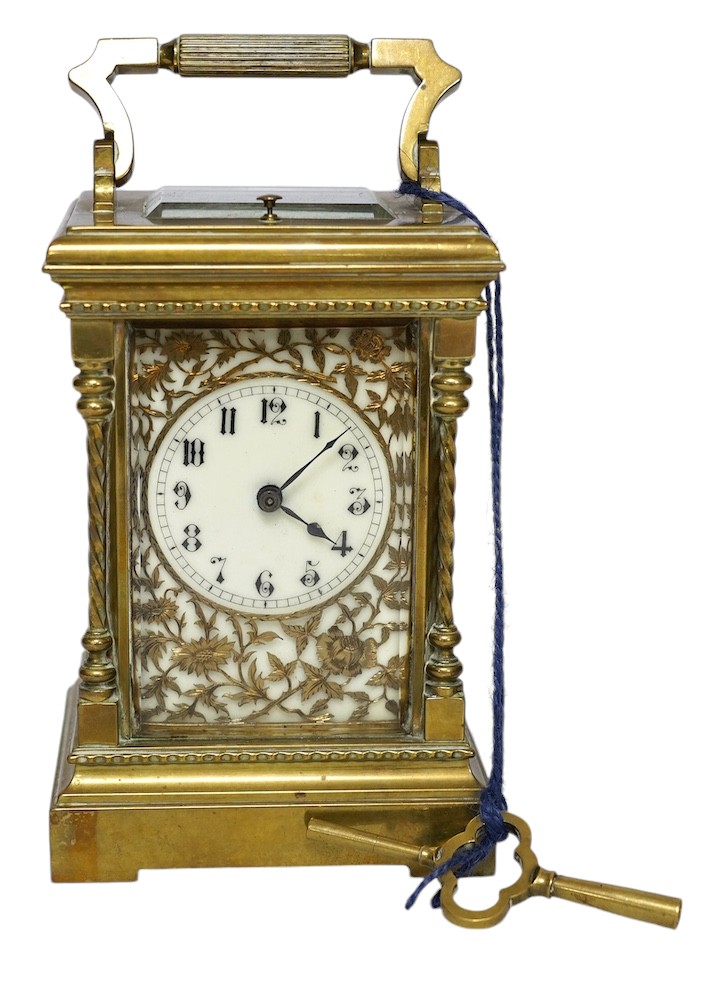 A large brass repeating carriage clock with key and ornate filigree dial, 17cm high (including handle). Condition - good, unchecked if working